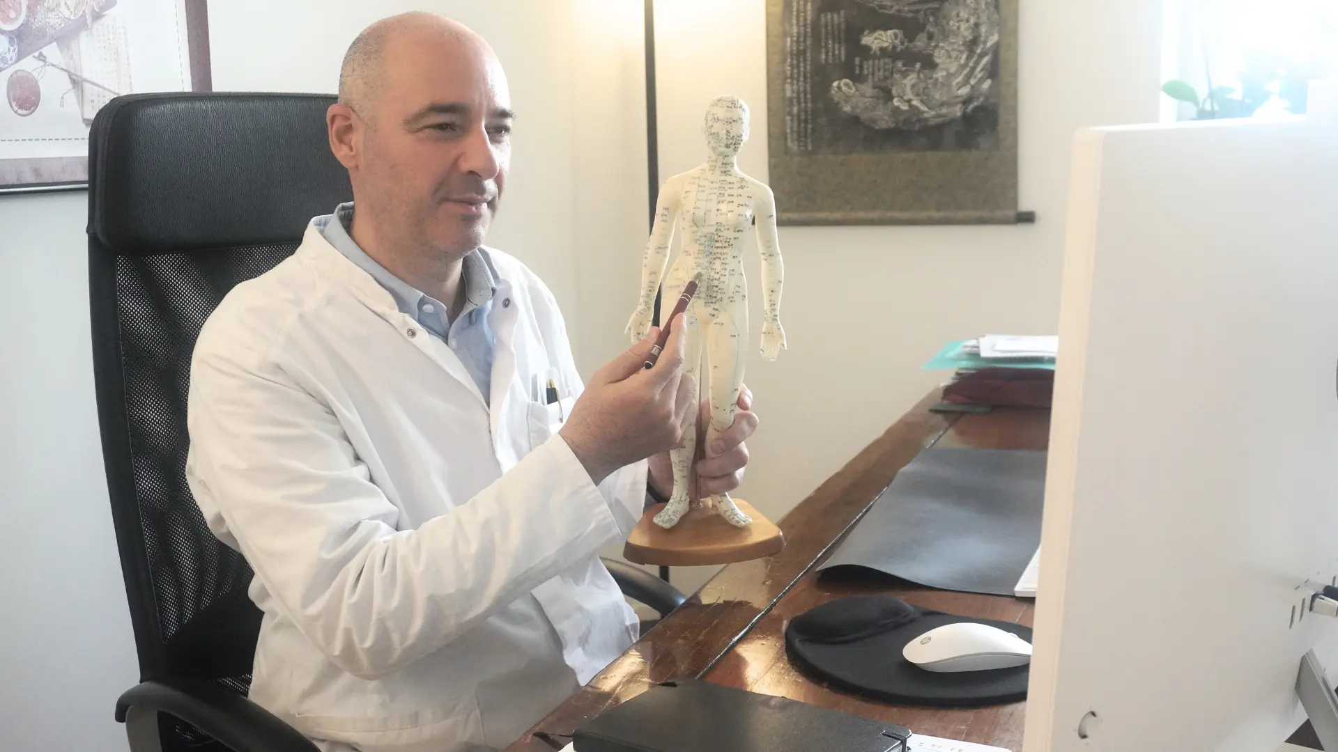 Un acupuncteur en téléconsultation qui montre un méridien